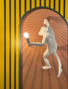 monkey sculpture with lit lightbulb