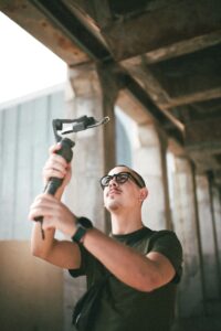 Young man records selfie with phone and selfie stick