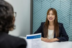 Image of a woman interviewing for a job with the interviewer holding her resume