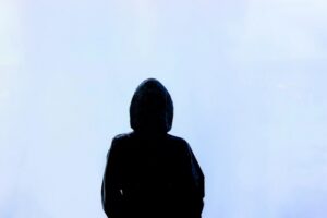 image of a black hooded figure against a white background