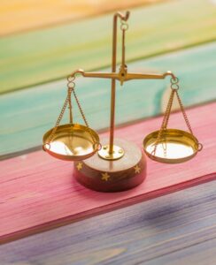 Image of a scale against a rainbow background